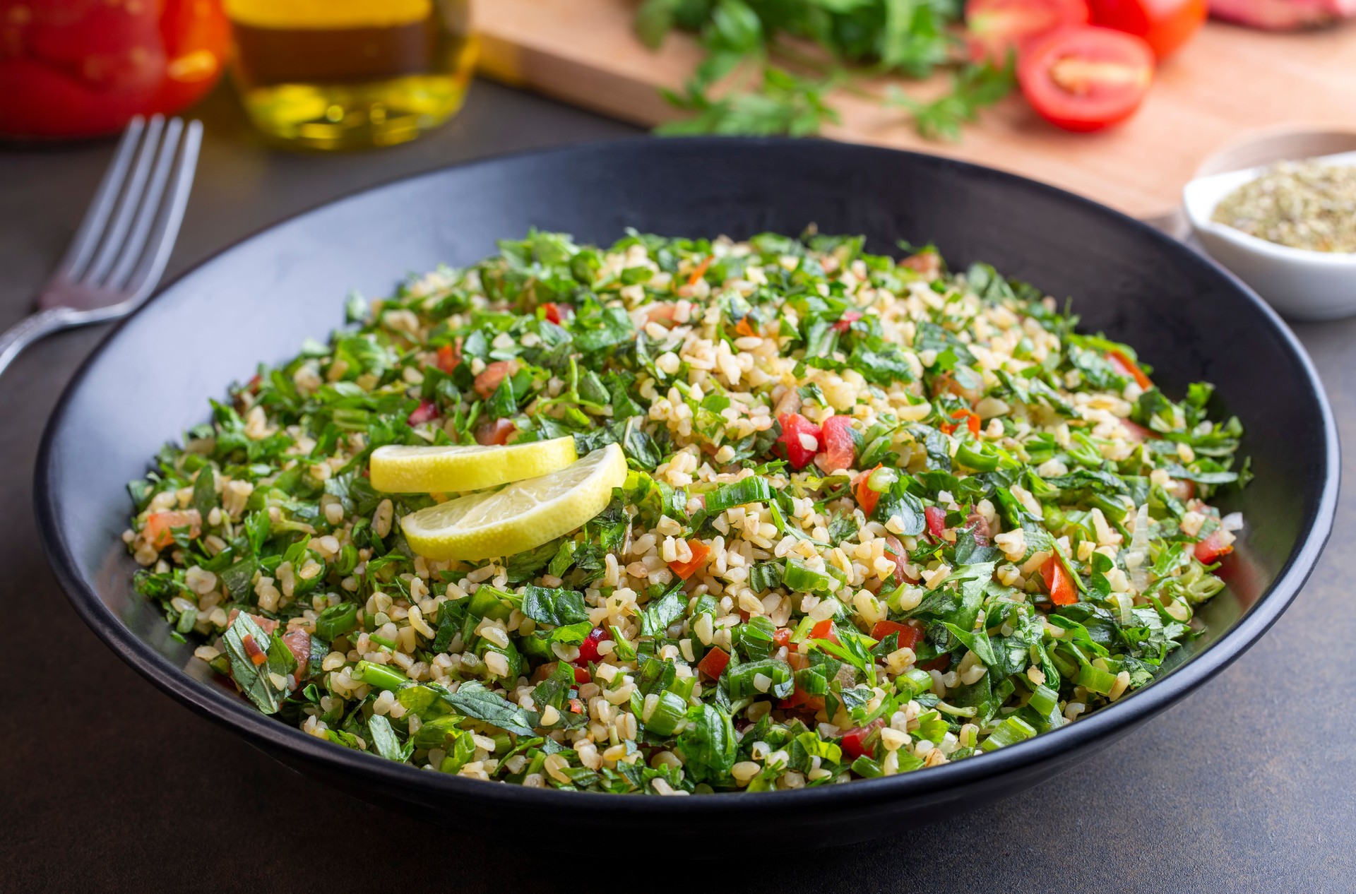 Traditional Lebanese salad tabouli tabule with quinoa, herbs, tomatoes, mint and lemon.