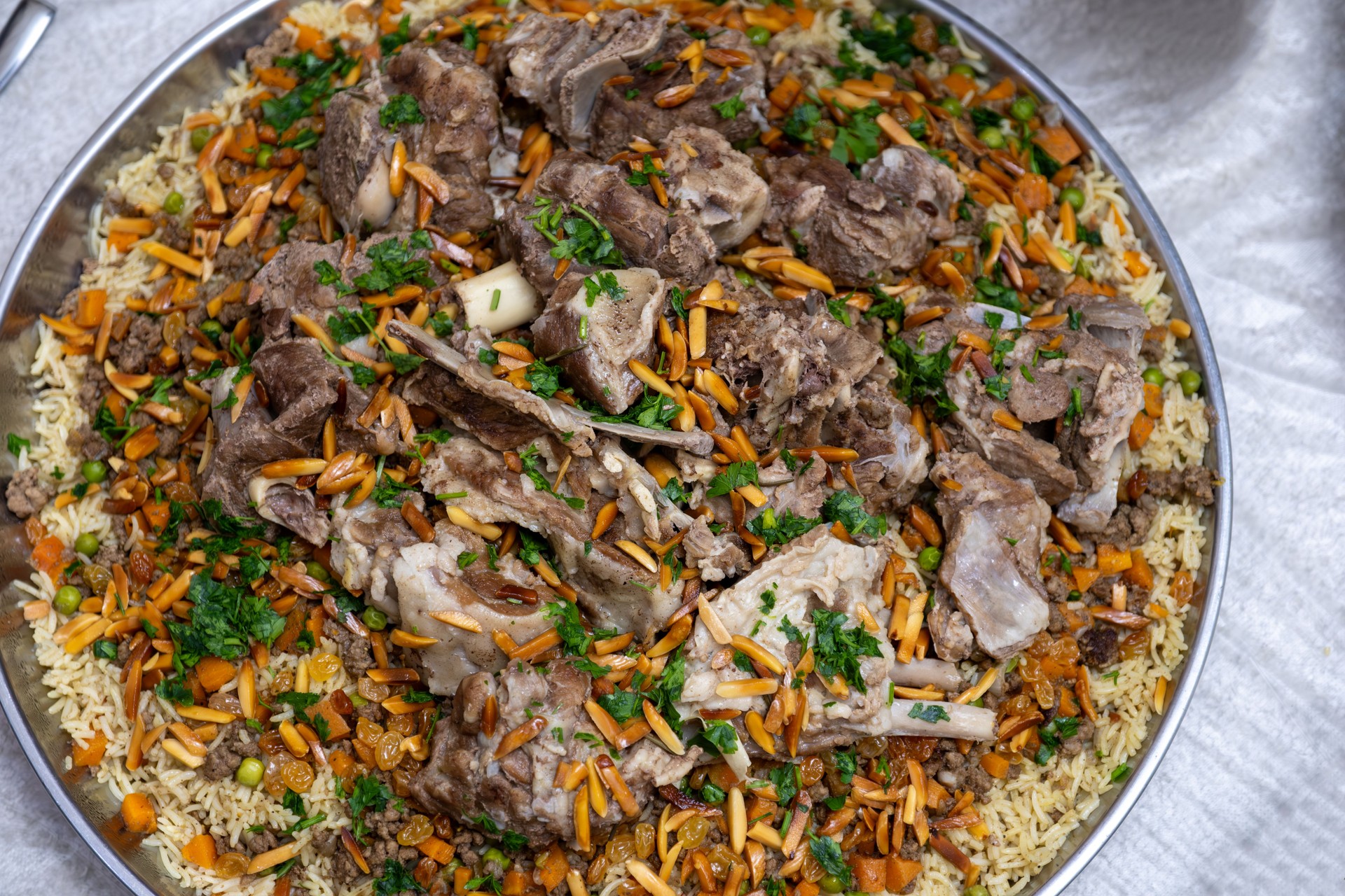 Arabic dish called ouzi made of lamb meat and rice topped with almonds and parsley, and mixed with lamb ghee