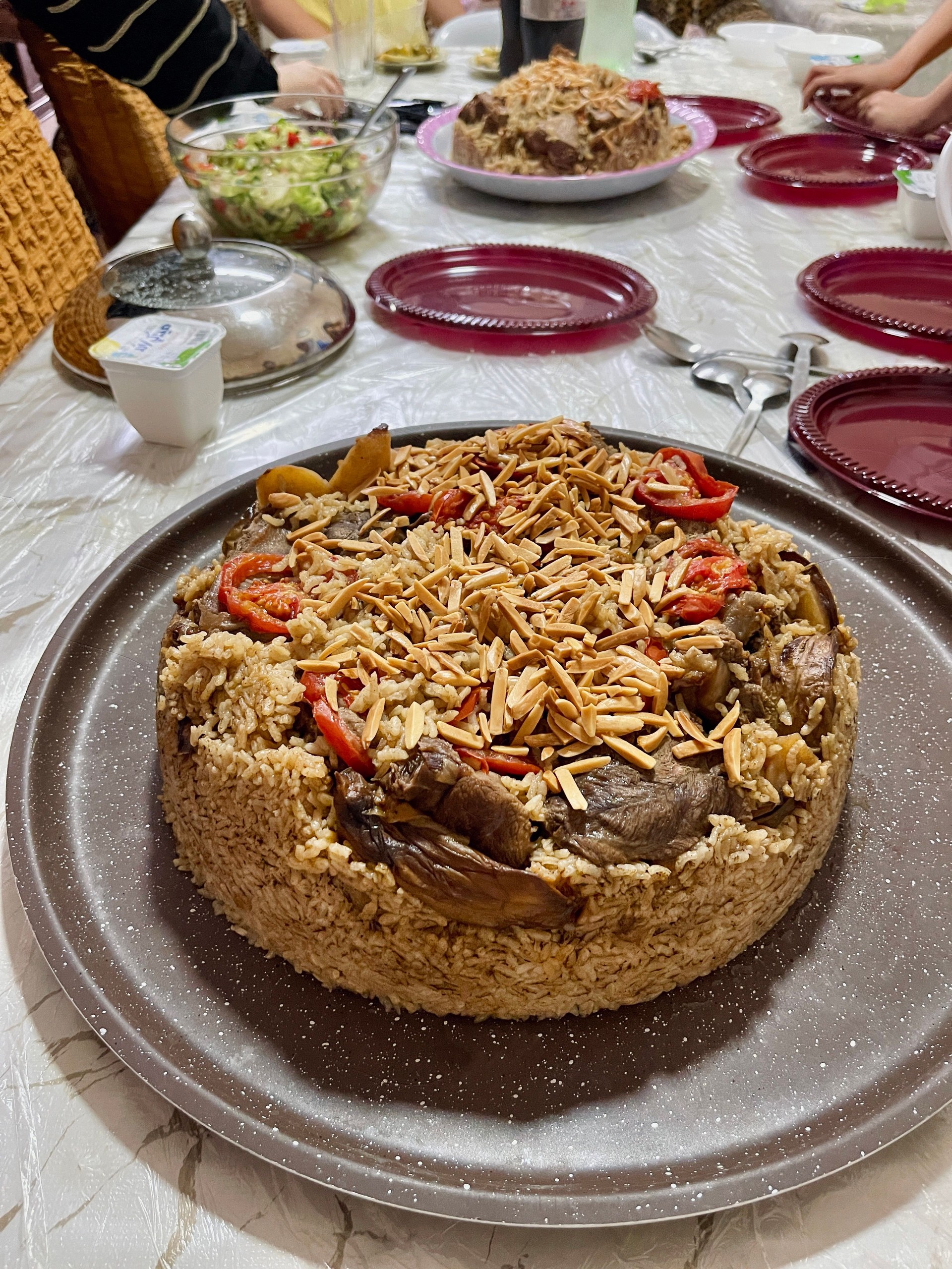 Traditional Palestinian maqluba with layers of rice, vegetables, beef, and eggplant, flipped and served as one pot dish